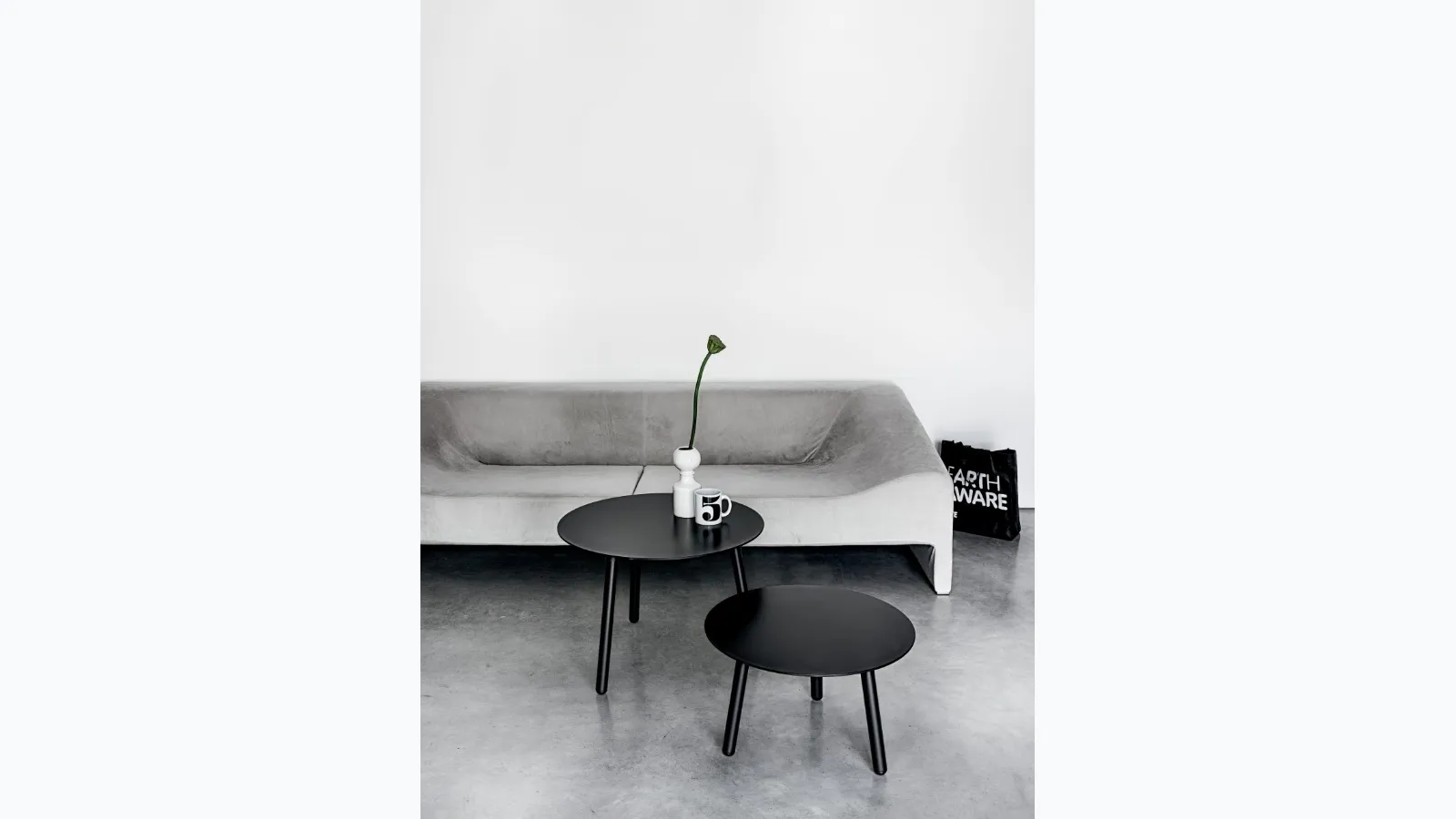 Tavolino rotondo con gambe in legno tinto e top in laminato nero disponibile in due altezze BCN Table di Kristalia